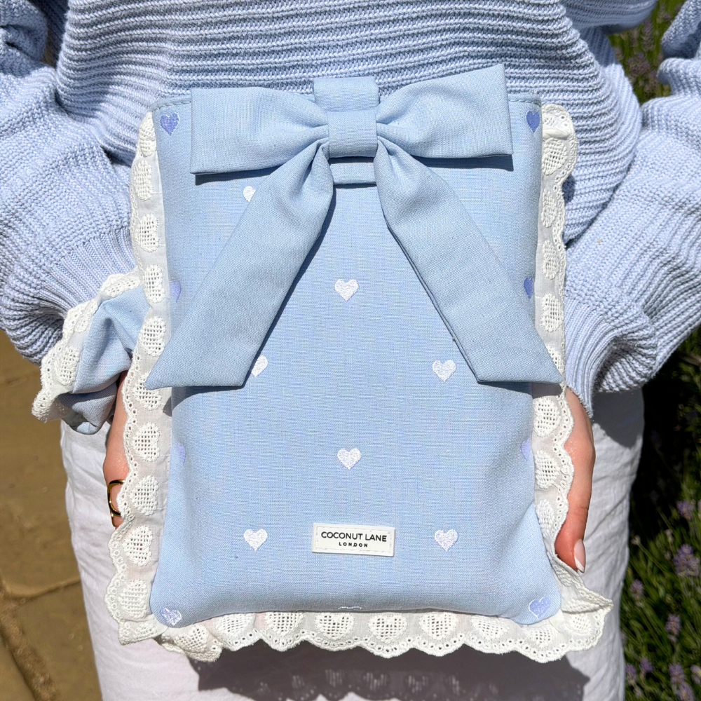 Close up image of girl in the sun holding the Blue Hearts Book Sleeve