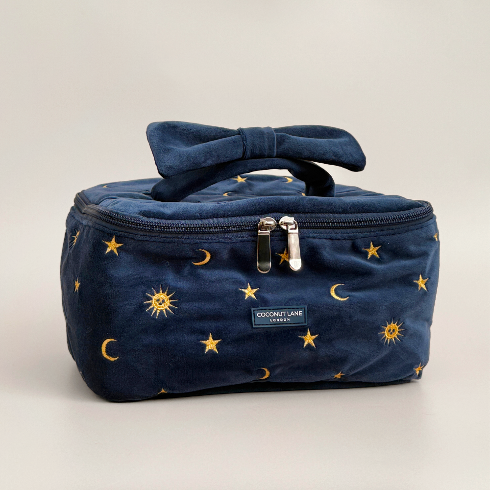 Navy velvet travel vanity case with gold celestial embroidery and a bow handle.
