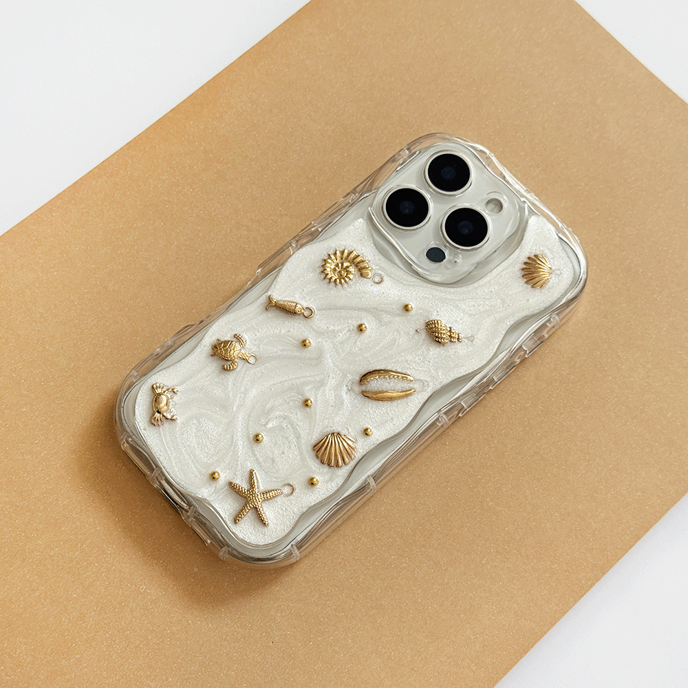 A clear phone case with a white pearlescent background, gold seashell and starfish embellishments, shown on a gold background.