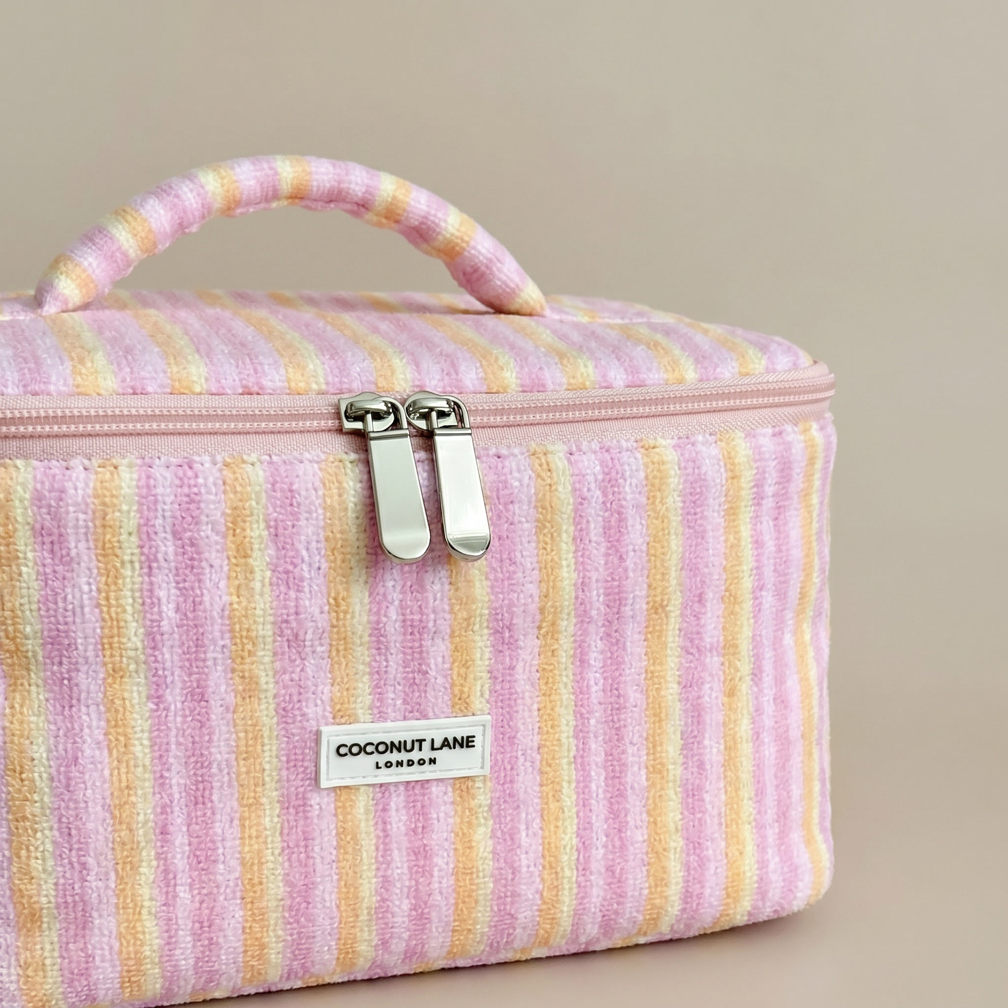 Pink, orange and yellow striped Vanity Bag in towel fabric with Coconut Lane logo.