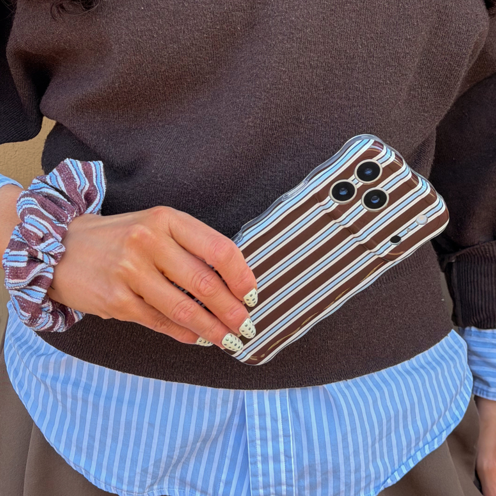 Girl wearing blue stripes shirt holding the Wavy Brown and Blue Stripes Phone Case