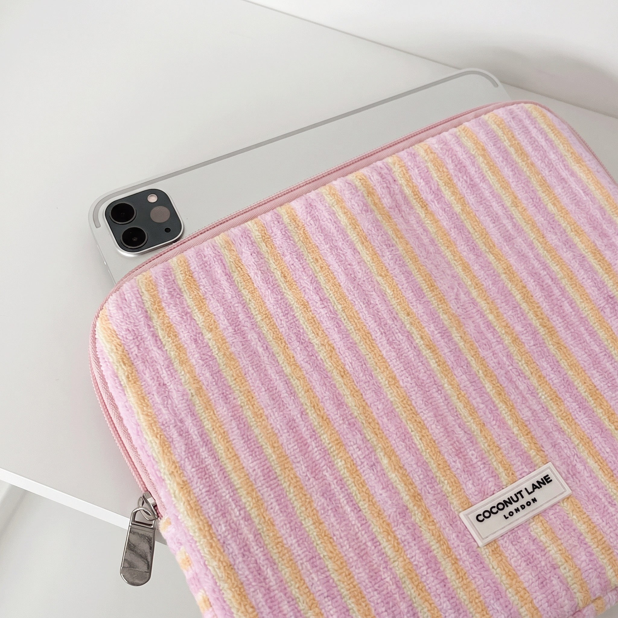 Pink, orange and yellow striped iPad Sleeve, with silver zip and Coconut Lane Logo.