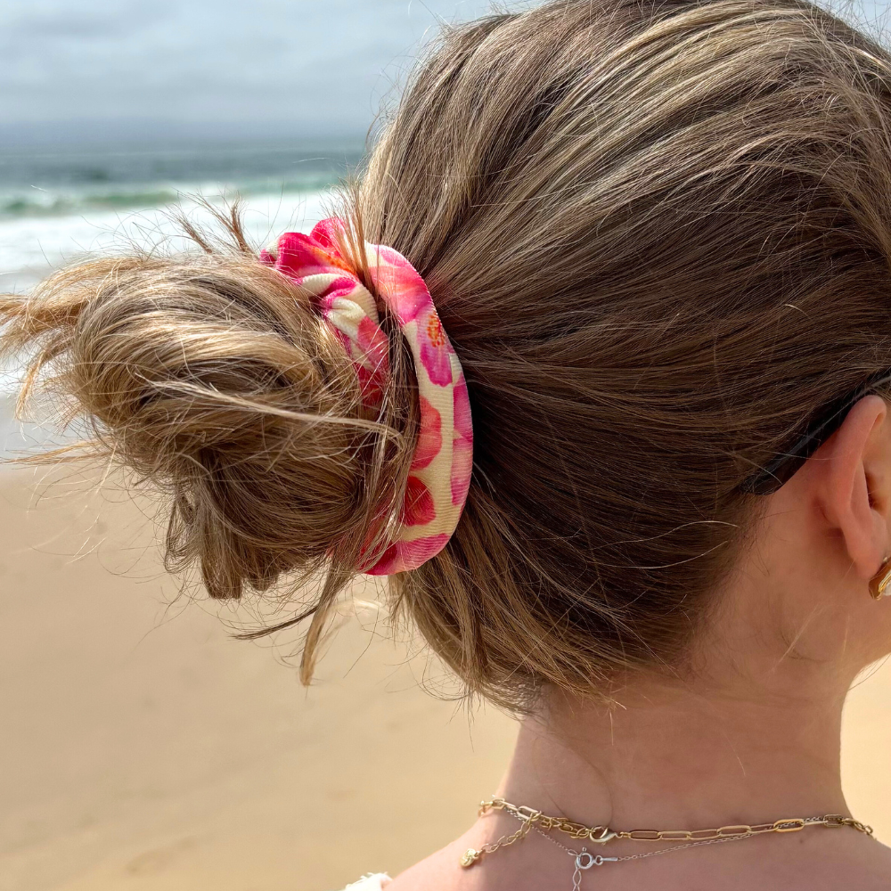 Woman wearing a messy bun secured with a yellow Coconut Lane scrunchie featuring a hibiscus pattern.