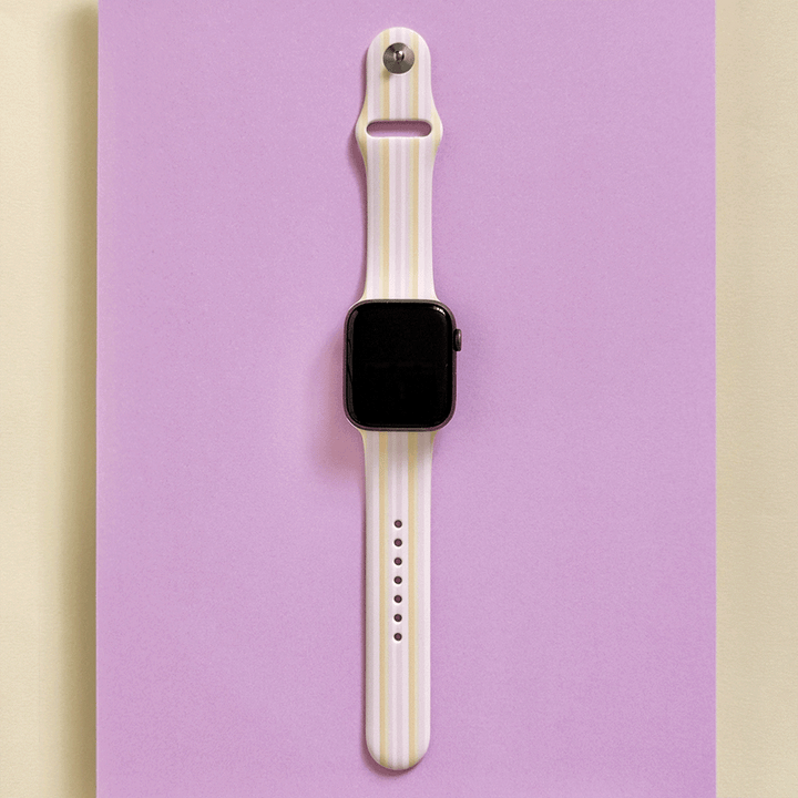 Apple Watch with a pastel stripe band on a purple background