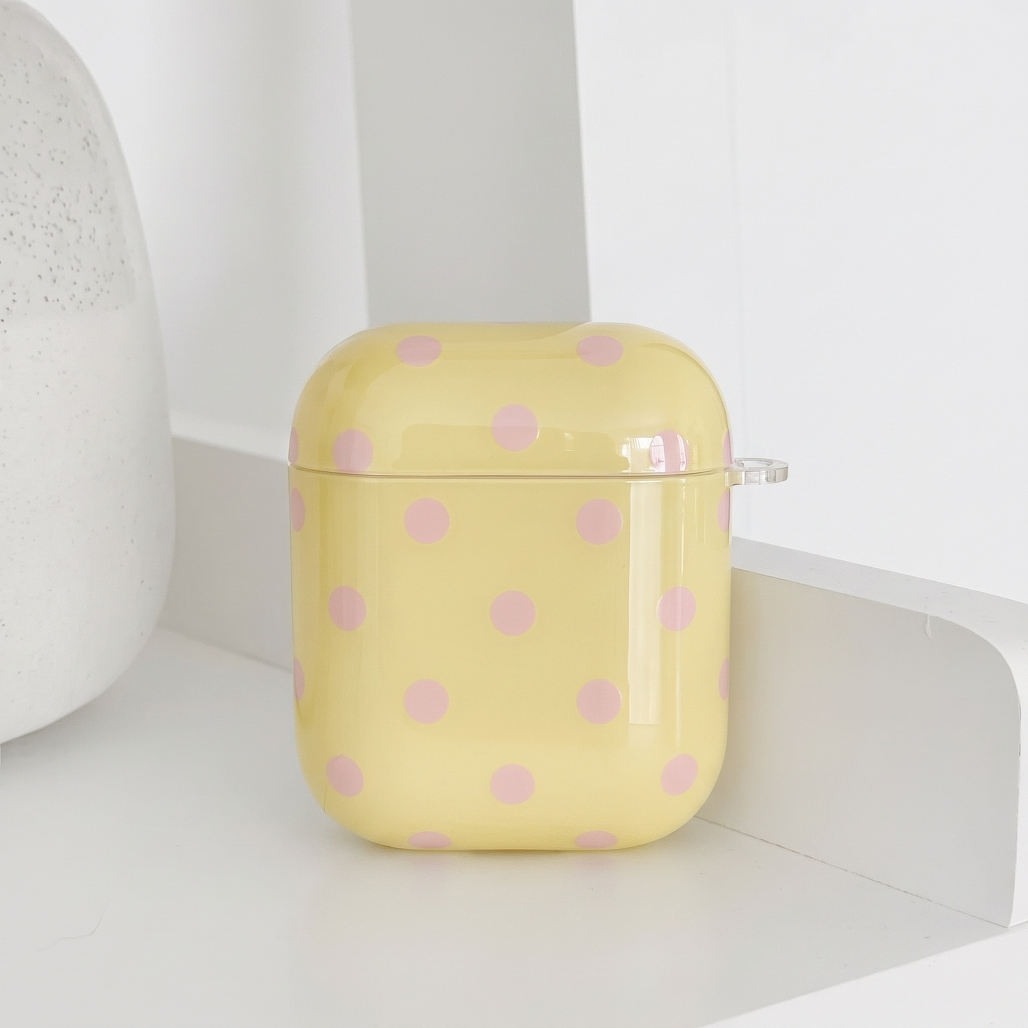 Pale yellow AirPods Case with baby pink polka dots.