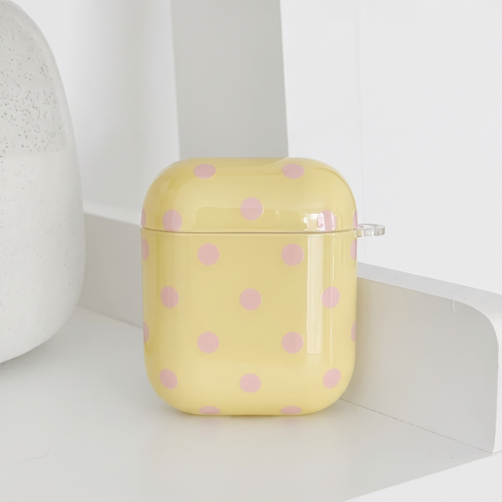 Pale yellow AirPods Case with baby pink polka dots.