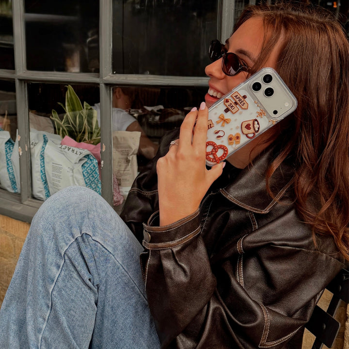 Woman wearing sunglasses, smiling on the phone with Apres Hour Phone Case on