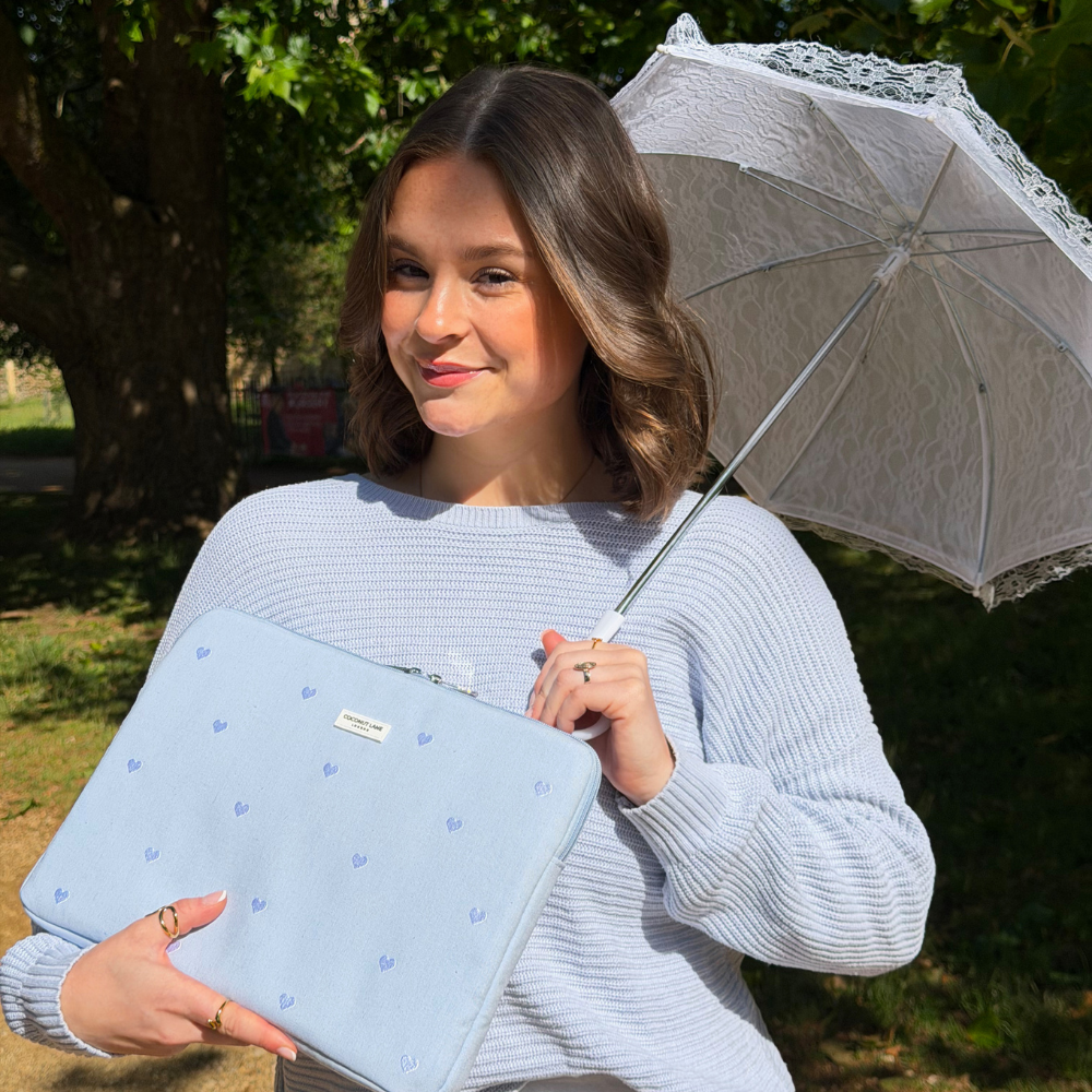 Girl smiling in the park holding her umbrella with her Blue Hearts Laptop Sleeve