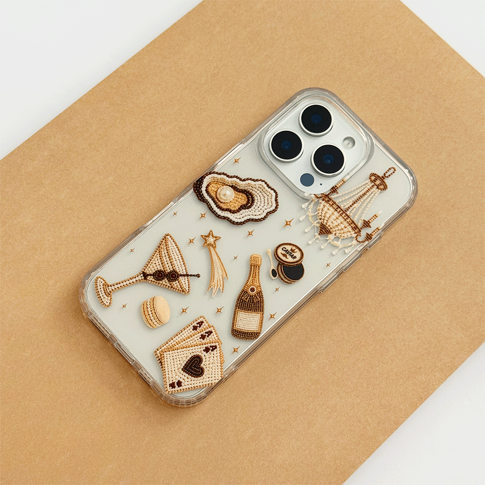 A clear phone case decorated with macron-style graphics of oysters, a cocktail, a champagne bottle, playing cards, and a macaron.