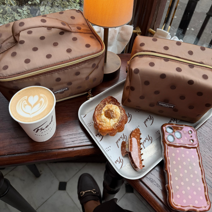 Dot Society chocolate brown makeup bag. Sheer mesh brown material with brown polka dot detailing. Alongside the matching claw clip, wavy phone case and vanity case.