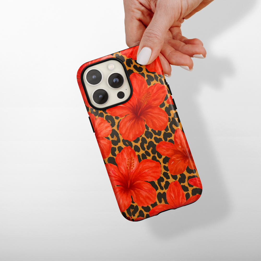 Hand holding Coconut Lane Tough Phone Case with a leopard and hibiscus print on a light background.
