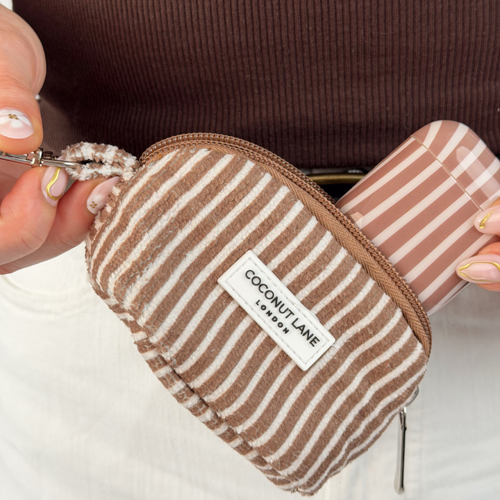 close up image of mini towel keyring bag in chestnut stripes with matching airpods