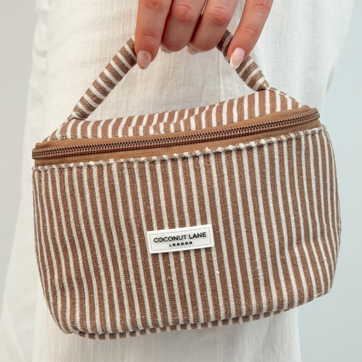 Girl holding mini travel vanity chestnut stripes by the handle