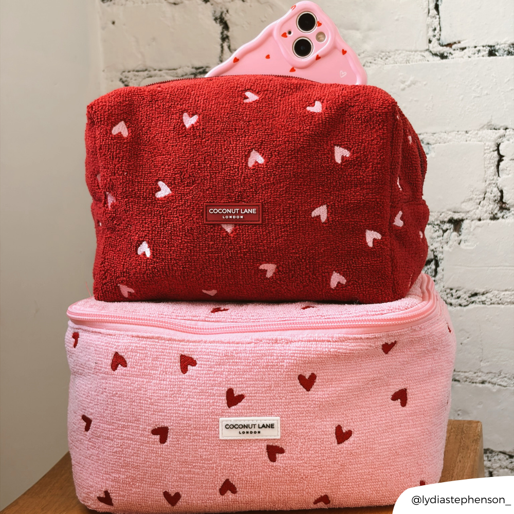 Pink Heart and Mulberry Heart makeup bags on top of each other in cafe setting