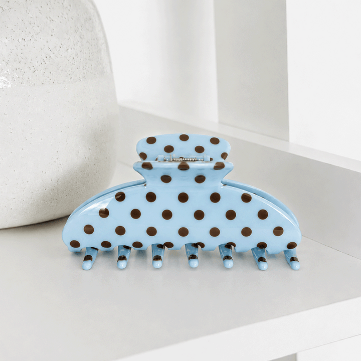 Blue hair clip with brown polka dots.
