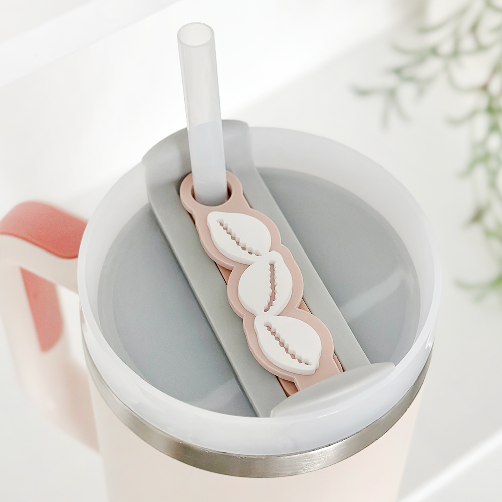 Nude beach shells tumbler topper on a Stanley cup lid with a clear straw, set against a white background.