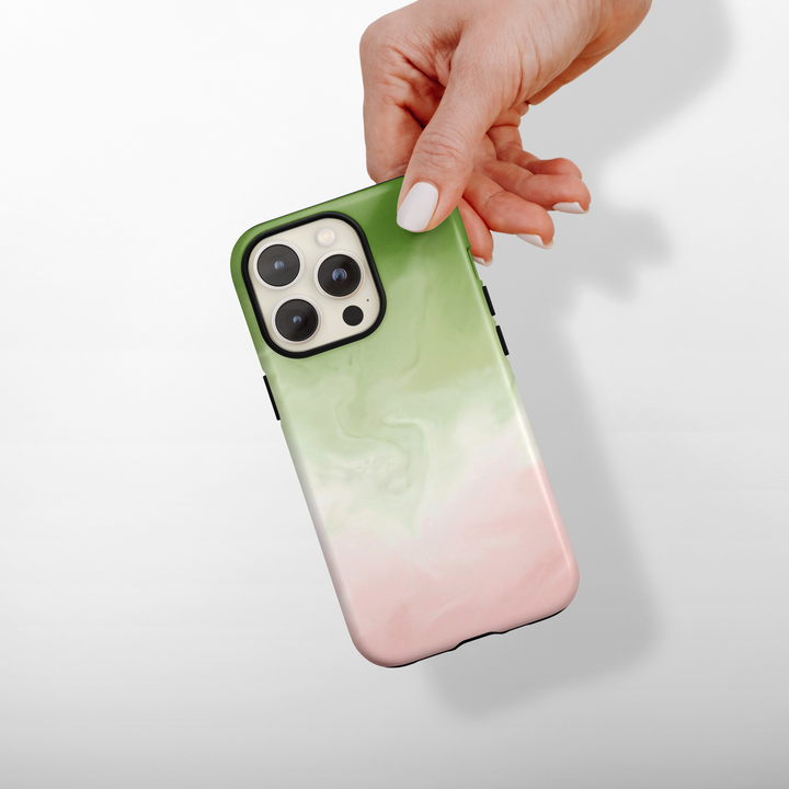 Phone case with a matcha and pink gradient design held by a hand on a light background