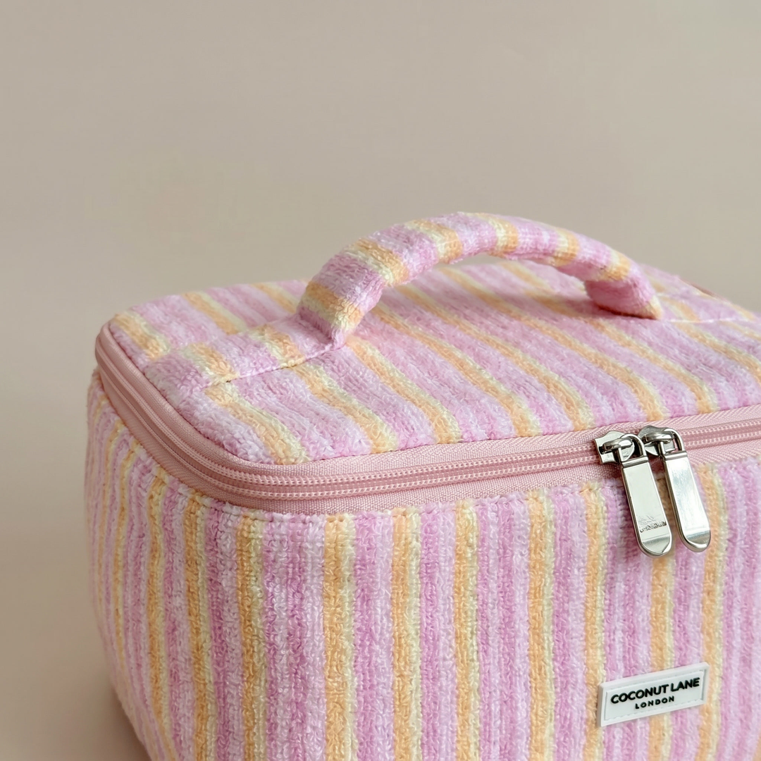 Pink, orange and yellow striped Vanity Bag in towel fabric with Coconut Lane logo.
