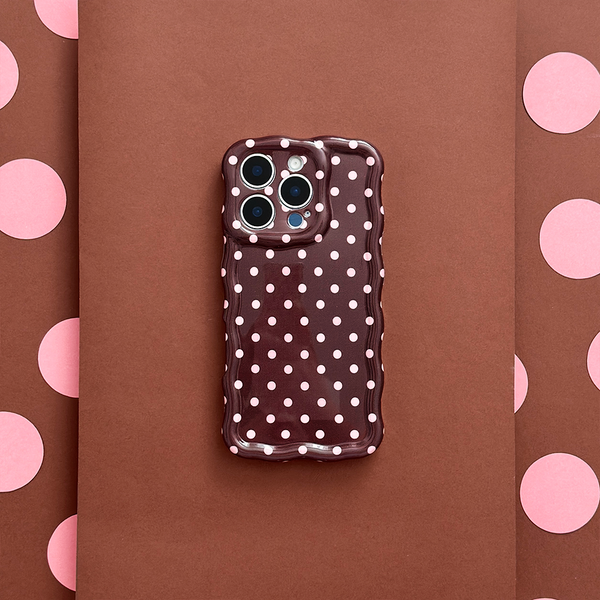 Coconut Lane wavy phone case with brown polka dots on a matching brown and pink polka dot background.