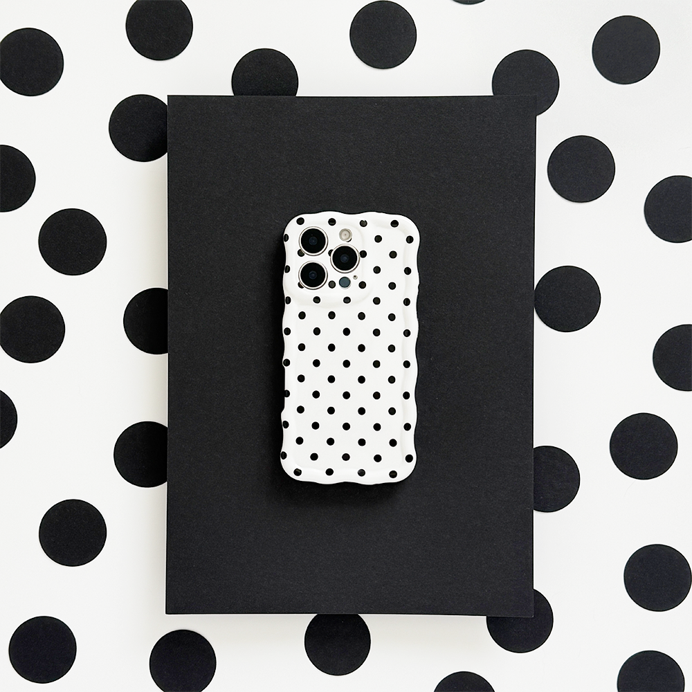 White polka dot wavy phone case by Coconut Lane on a phone, set against a matching polka dot background.