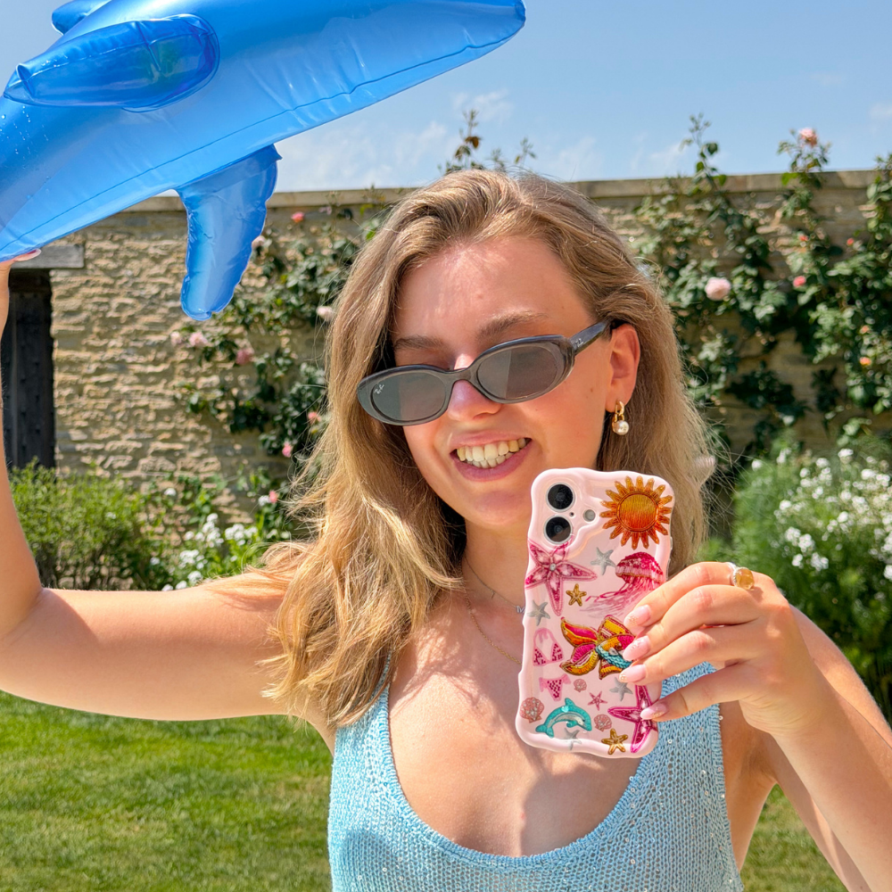 Girl smiling holding Wavy Pink Paradise Phone Case wearing blue sequin dress