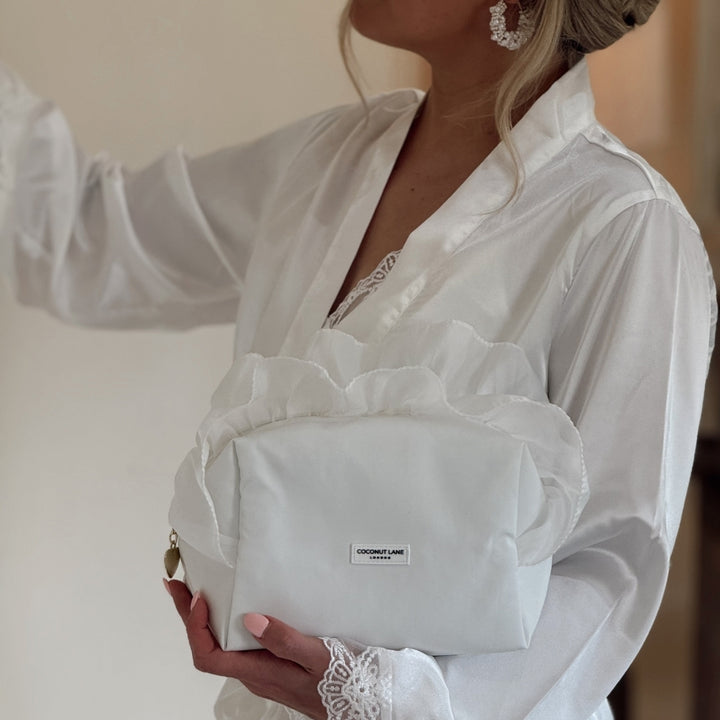 Bride in satin dressing gown holding White Ruffle Satin Makeup Bag