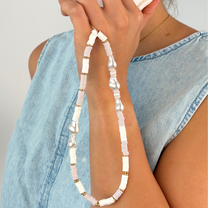 Close up of the beaded nude and pearl phone strap in studio shoot