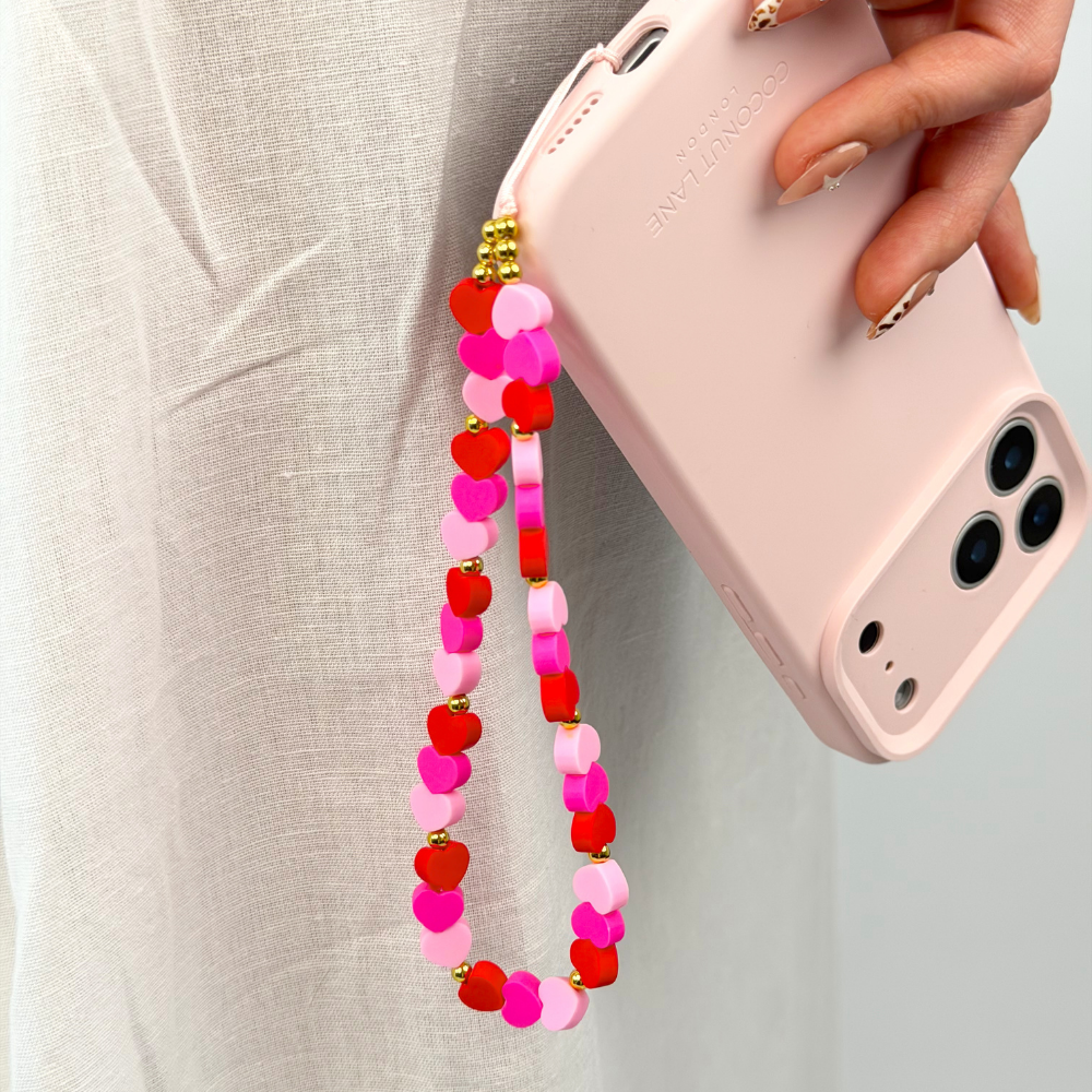 close up of hearts phone strap attached to butter soft pink phone case