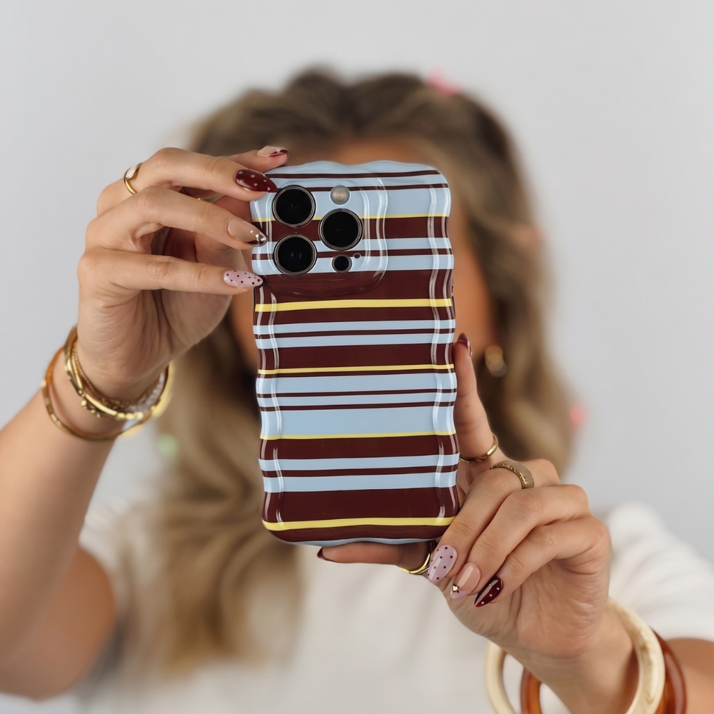 A blue,brown and yellow striped wavy phone case being held by a girl in front of her face